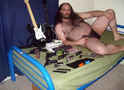 guy_on_bed_with_guns.jpg
